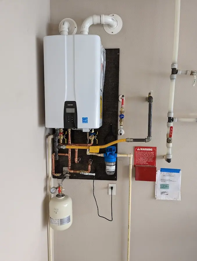 Professional plumber installing copper piping in a New London home